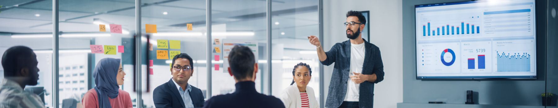 business man doing a presentation in front of his peers in an office