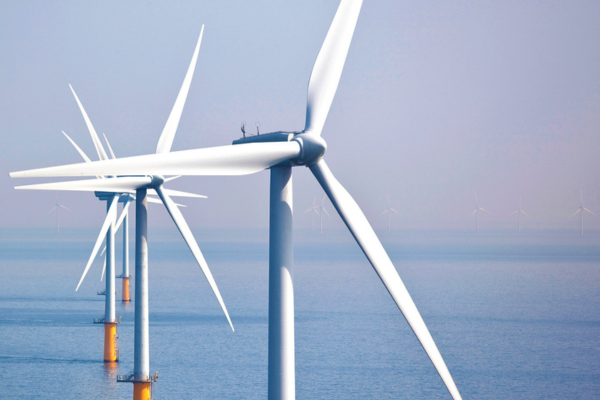 Several white offshore wind turbines stand in the ocean, with three close ones in focus and more faintly visible in the background, under a clear sky. | Bentley Systems | Infrastructure Engineering Software Company Several white offshore wind turbines stand in the ocean, with three close ones in focus and more faintly visible in the background, under a clear sky.